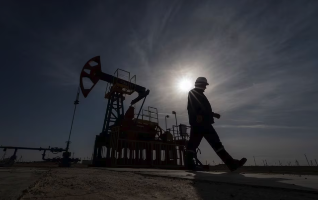 An oil and gas industry worker walks during operations of a drilling rig at Zhetybay field in Kazakhstan